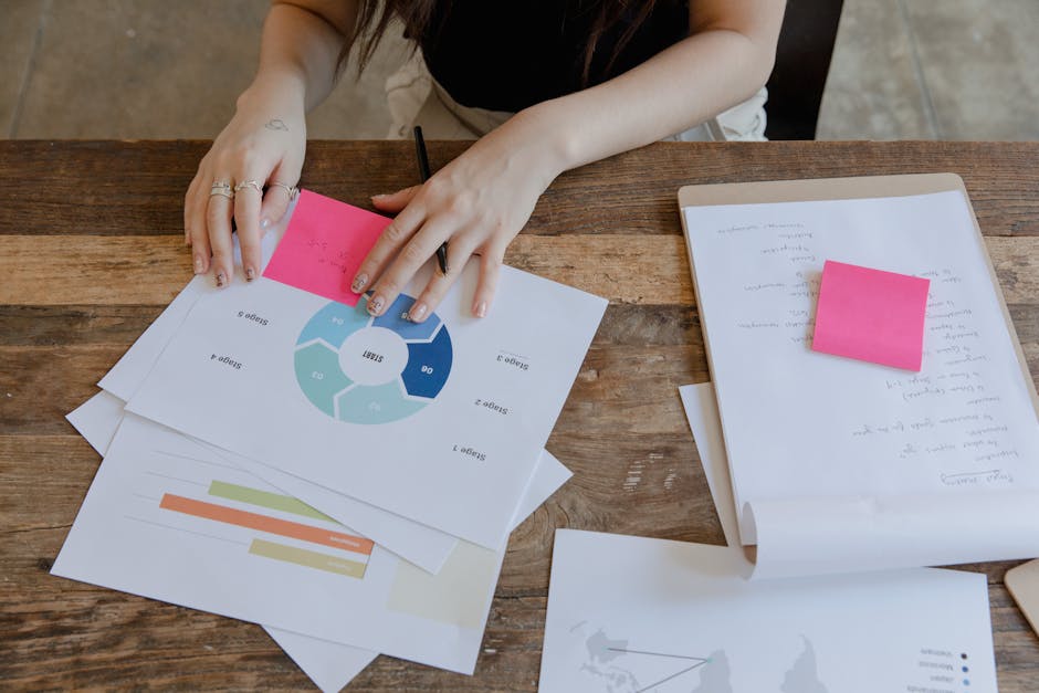 Overhead view of a workspace featuring data charts and sticky notes for business planning.